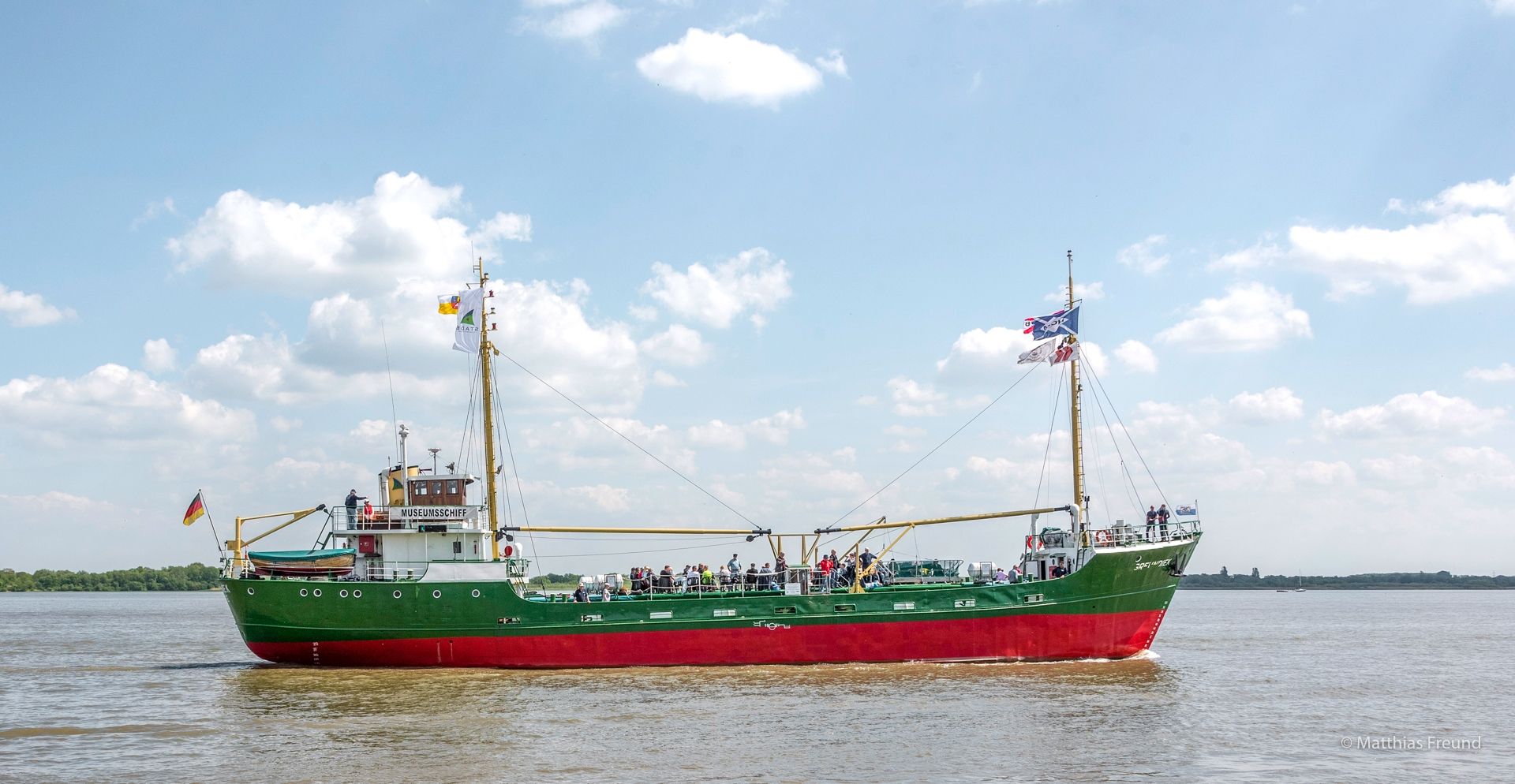 Die Greundiek in voller Länge auf der Elbe, an beiden Masten wehen Flaggen