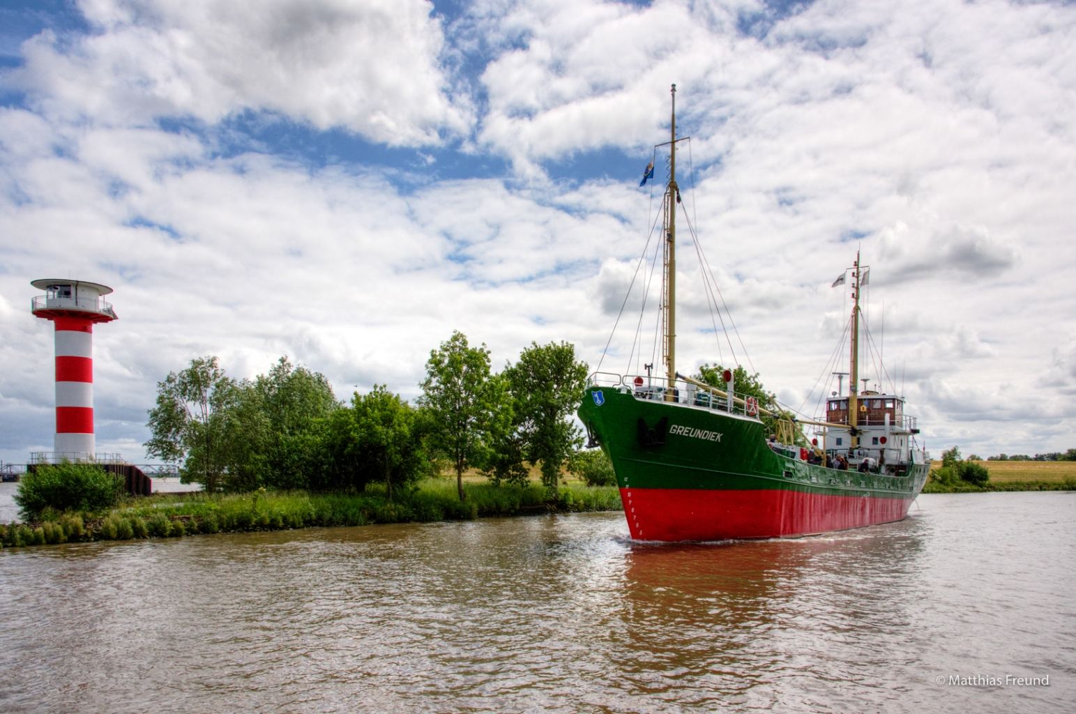 Die Greundiek auf der Schwinge vor einem rot-weißen Leuchtturm